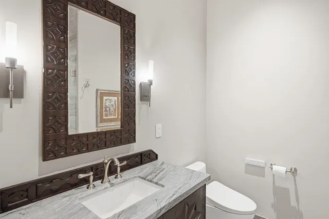 a bathroom with a sink a toilet and mirror