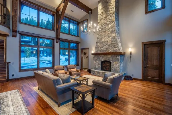 a living room with furniture large window and wooden floor