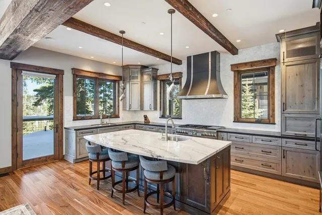 a kitchen with a table chairs sink and wooden floor