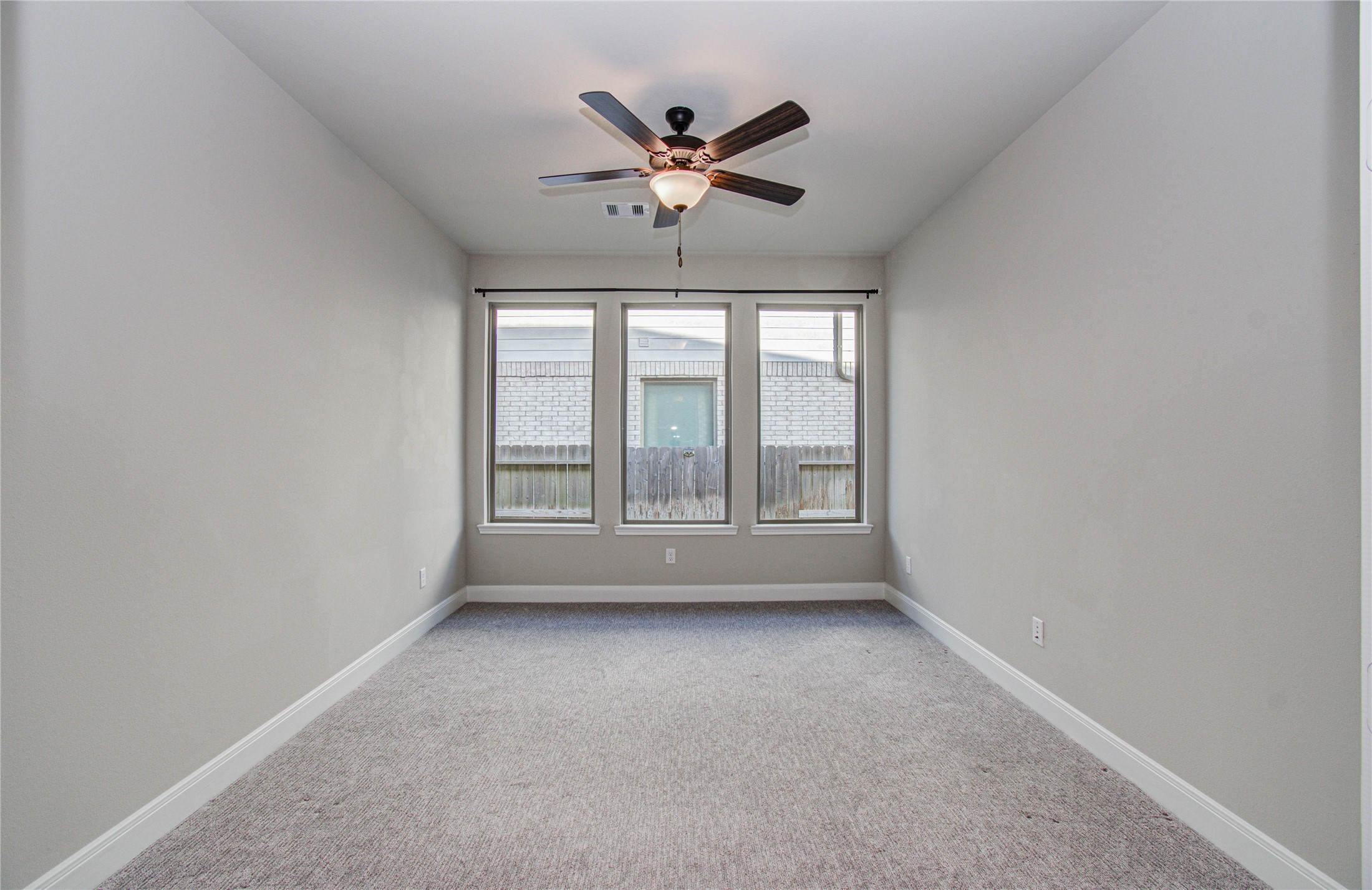 17344 Grand Canyon Road Conroe, TX 77302 - Photo 11 of 49 This room is bright and cozy, featuring neutral walls and carpet. It includes a ceiling fan for comfort and three large windows providing natural light and a view of the backyard.