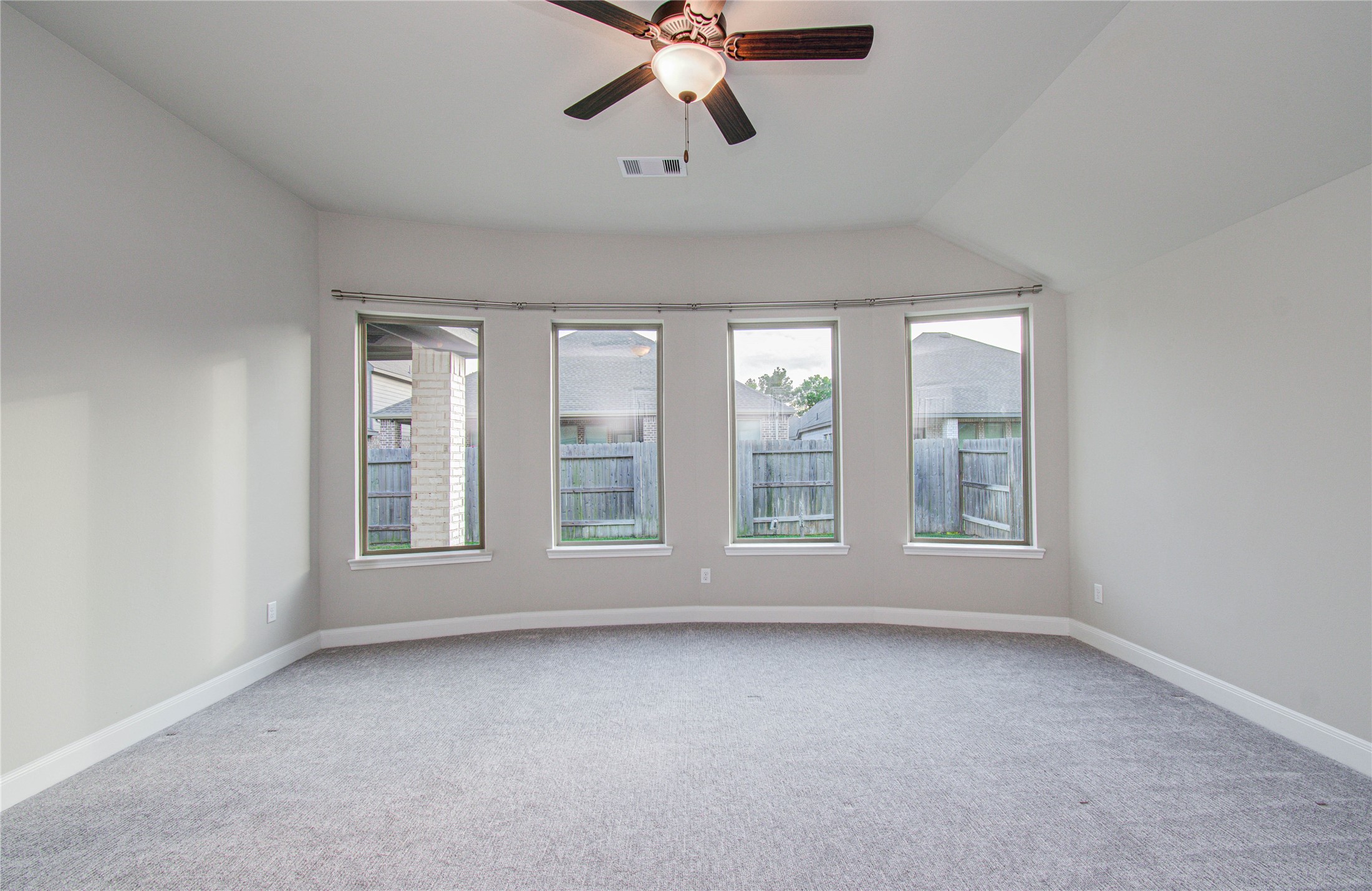 17344 Grand Canyon Road Conroe, TX 77302 - Photo 25 of 49 Bright, spacious room with large windows offering plenty of natural light, neutral walls, and carpet flooring. A ceiling fan provides comfort and style. Perfect for a cozy living space or bedroom.