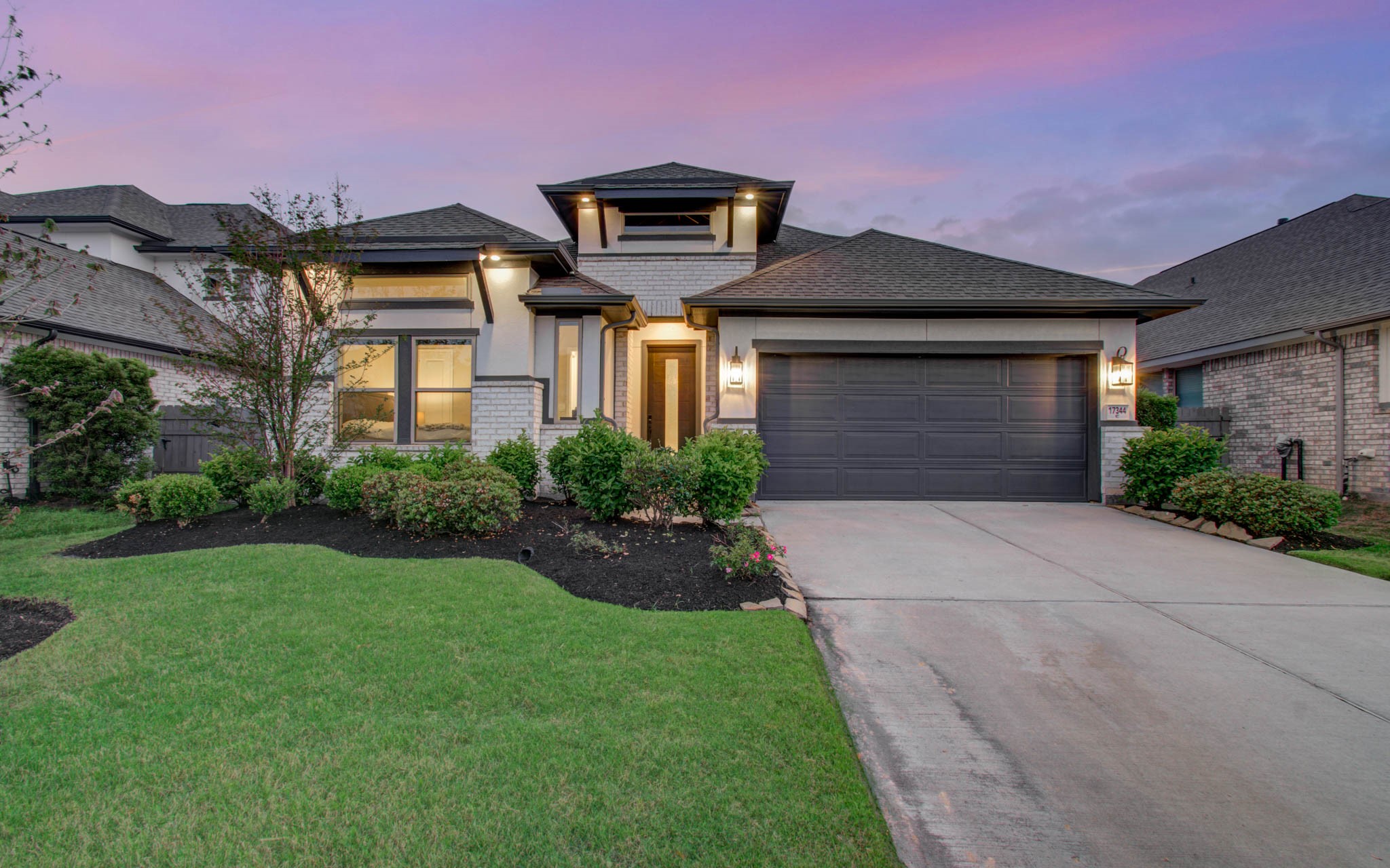 17344 Grand Canyon Road Conroe, TX 77302 - Photo 41 of 49 This charming home features a modern exterior with a two-car garage and well-maintained landscaping. The warm lighting and manicured lawn create an inviting atmosphere, perfect for families.