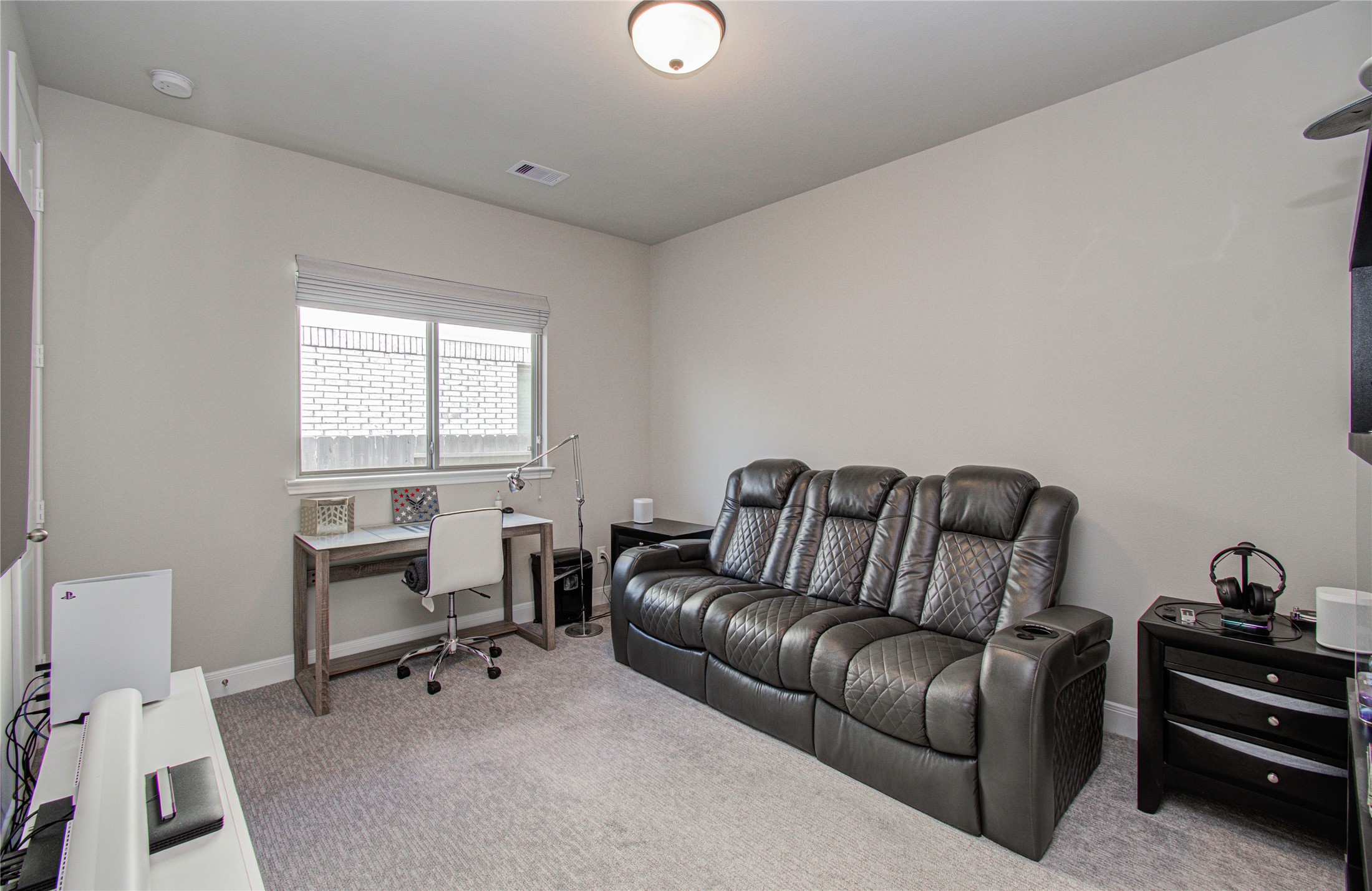 17344 Grand Canyon Road Conroe, TX 77302 - Photo 7 of 49 This room features a cozy setup with a large leather recliner sofa, a compact desk with a chair, and natural light from a window. Ideal for a home office or entertainment space.