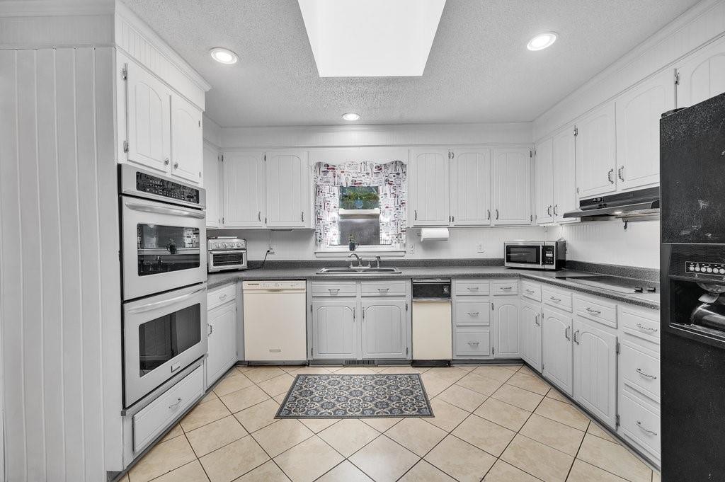 4655 Lake Shore Road North Denver, NC 28037 - Photo 13 of 31 a kitchen with granite countertop white cabinets stainless steel appliances a sink and a counter top space