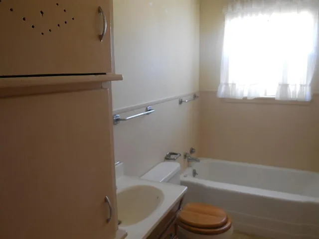 a bathroom with a tub and a toilet
