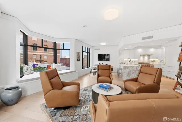 a living room with furniture and a view of kitchen