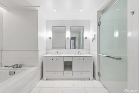 a spacious bathroom with a bathtub sink and mirror