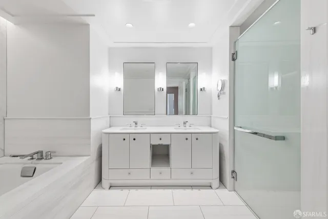 a spacious bathroom with a bathtub sink and mirror