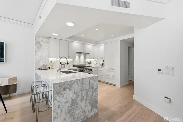a kitchen with stainless steel appliances a sink a stove a refrigerator and cabinets