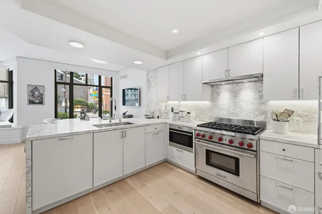 a kitchen with stainless steel appliances a stove sink and cabinets