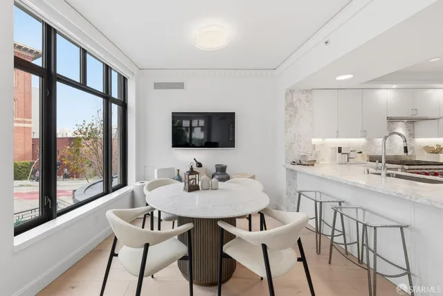 a kitchen with a dining table chairs and window