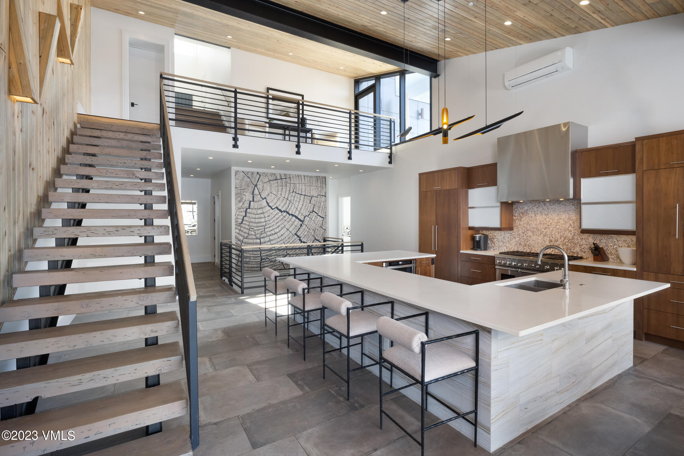 2350 Sequoia Drive Vail, CO 81657 - Photo 3 of 10 a kitchen with stainless steel appliances kitchen island a table chairs in it and wooden floors