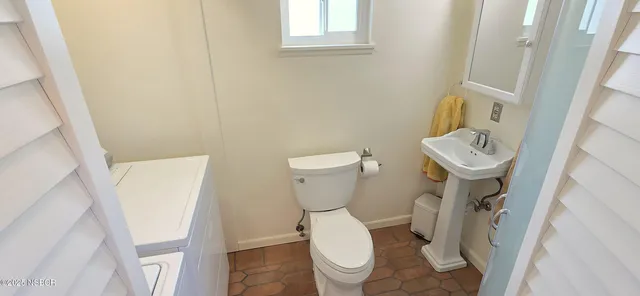 a bathroom with a toilet sink and mirror