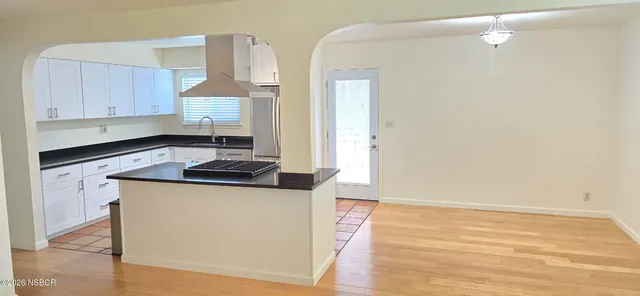 a kitchen with granite countertop a sink cabinets and stainless steel appliances
