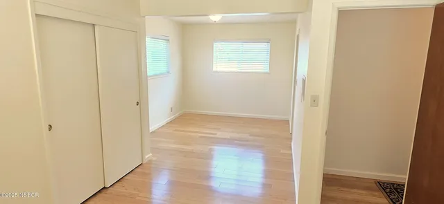 a view of an empty room with wooden floor