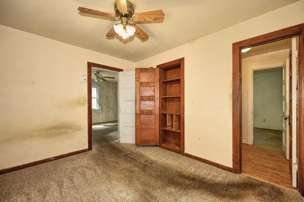 a view of a livingroom with a ceiling fan & entryway