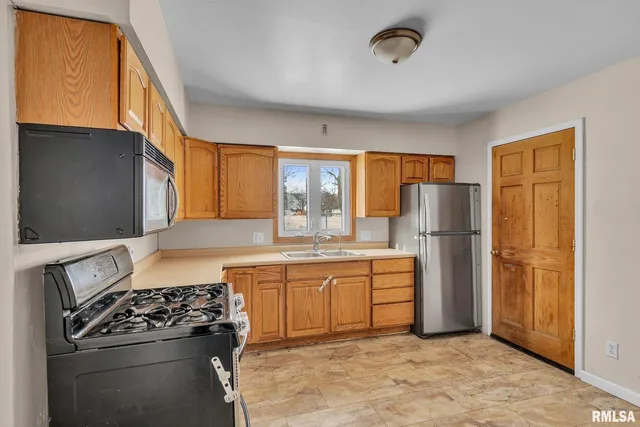 a kitchen with stainless steel appliances granite countertop a refrigerator stove and sink