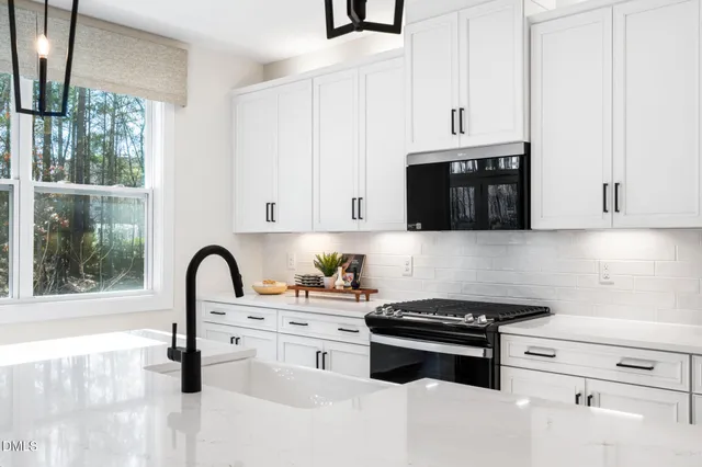 a kitchen with stainless steel appliances kitchen island a white stove top oven and sink