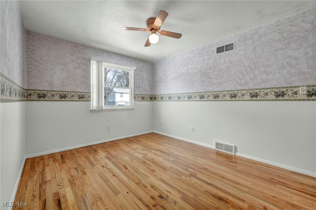 2514 Primewood Road Akron, OH 44305 - Photo 24 of 49 Empty room with wallpapered walls, light wood-style floors, a textured ceiling, and ceiling fan
