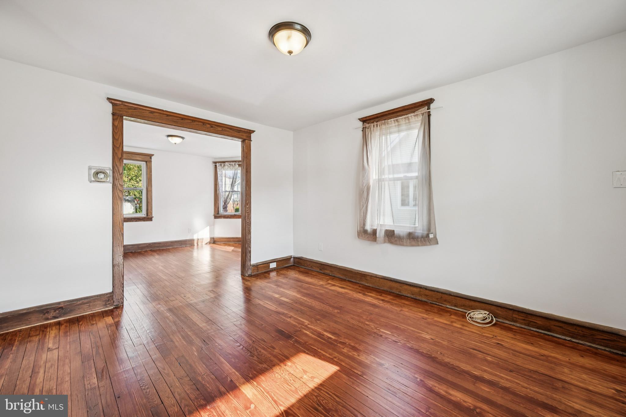 211 Newton Avenue Oaklyn, NJ 08107 - Photo 5 of 25 a view of an empty room with wooden floor and a window