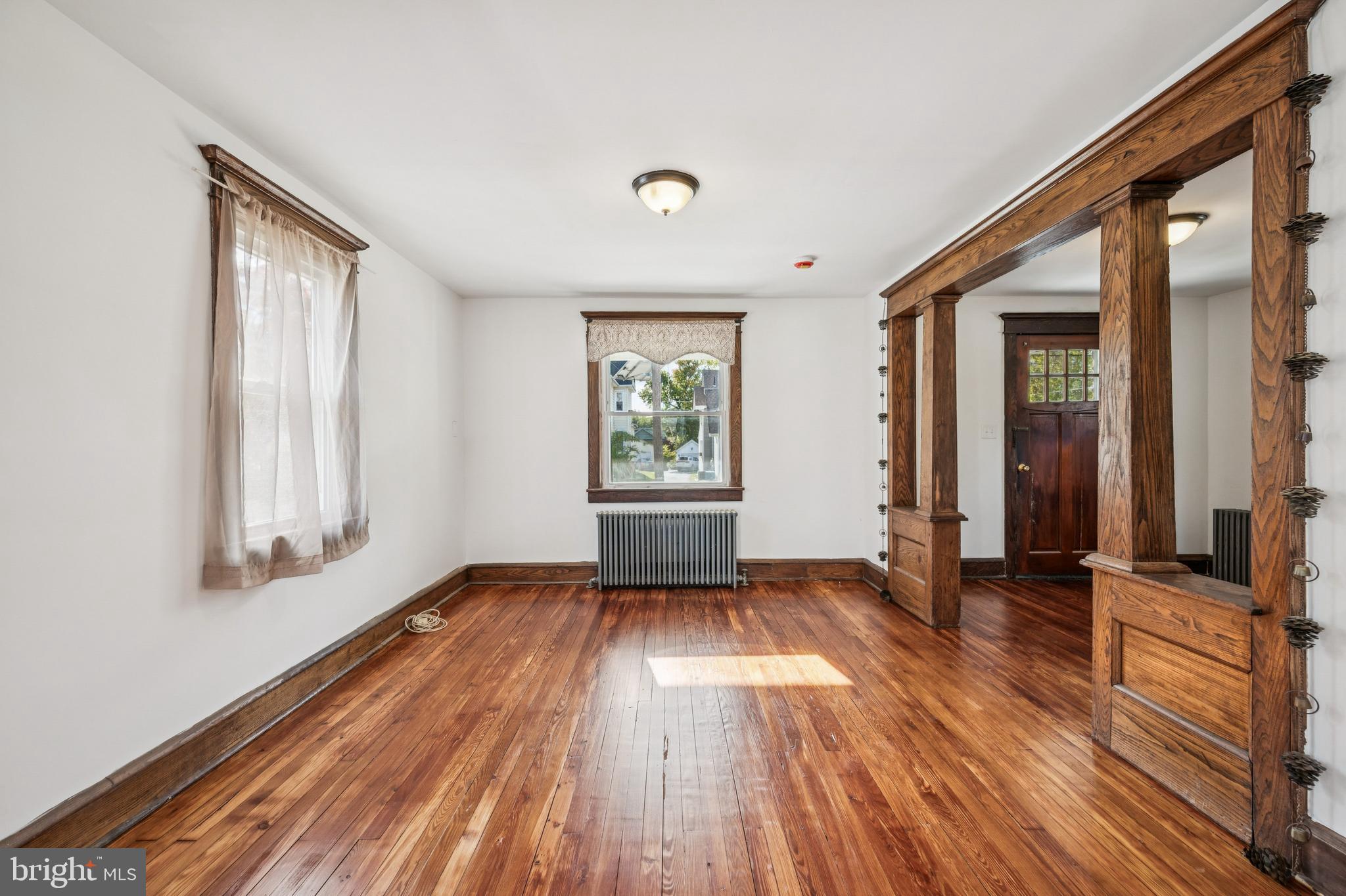 211 Newton Avenue Oaklyn, NJ 08107 - Photo 7 of 25 an empty room with wooden floor and windows