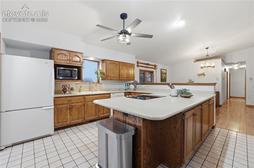 18190 Forest View Road Monument, CO 80132 - Photo 19 of 50 a kitchen with a sink a stove and chairs