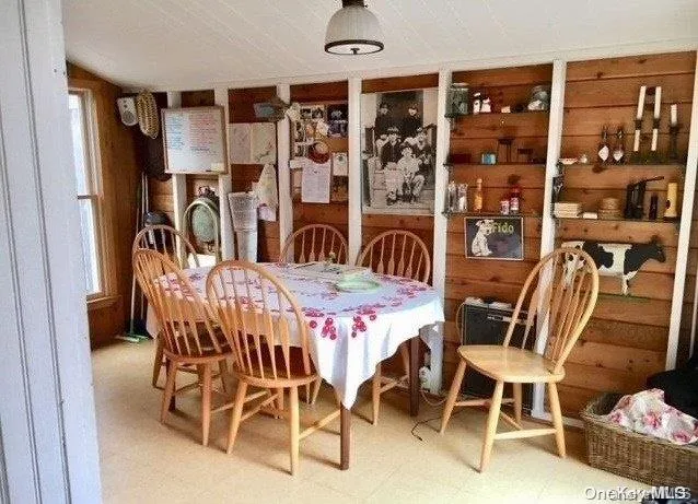 a dining area with furniture a rug and a window