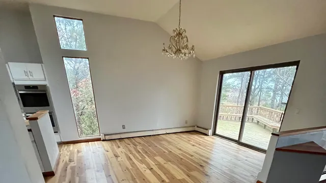 a view of a hallway with wooden floor and staircase