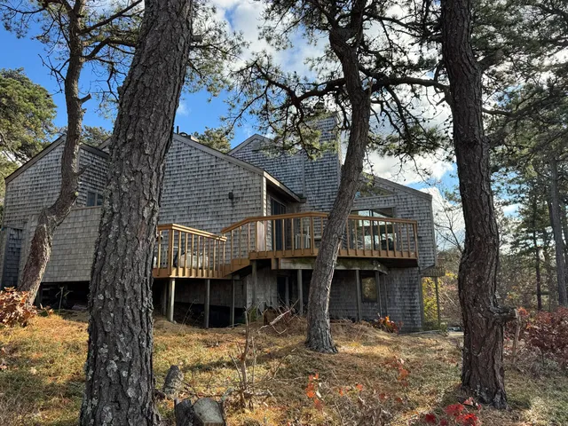 a front view of a house with a tree