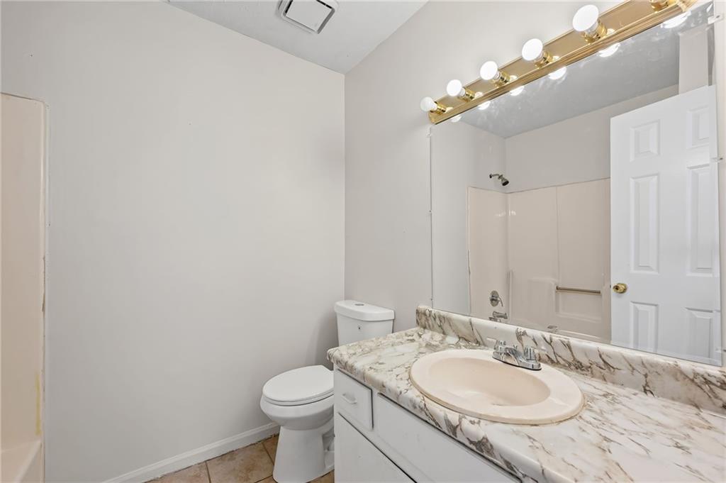 1222 Ridgecrest Lane Southeast Smyrna, GA 30080 - Photo 20 of 27 a bathroom with a granite countertop sink a toilet and a mirror