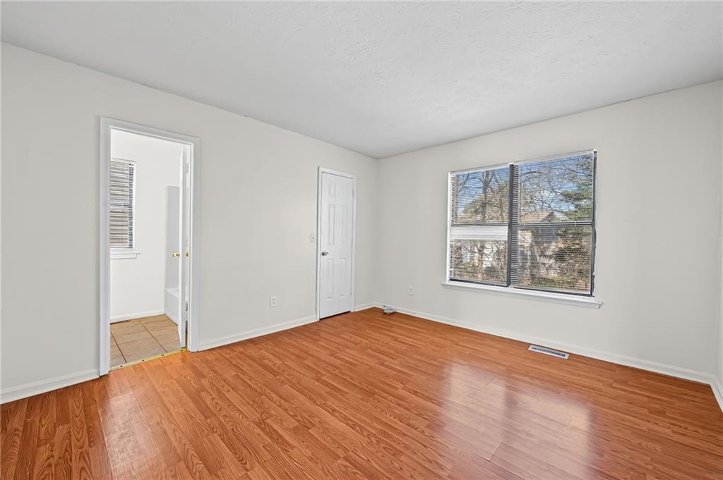 1222 Ridgecrest Lane Southeast Smyrna, GA 30080 - Photo 22 of 27 a view of an empty room with wooden floor and a window