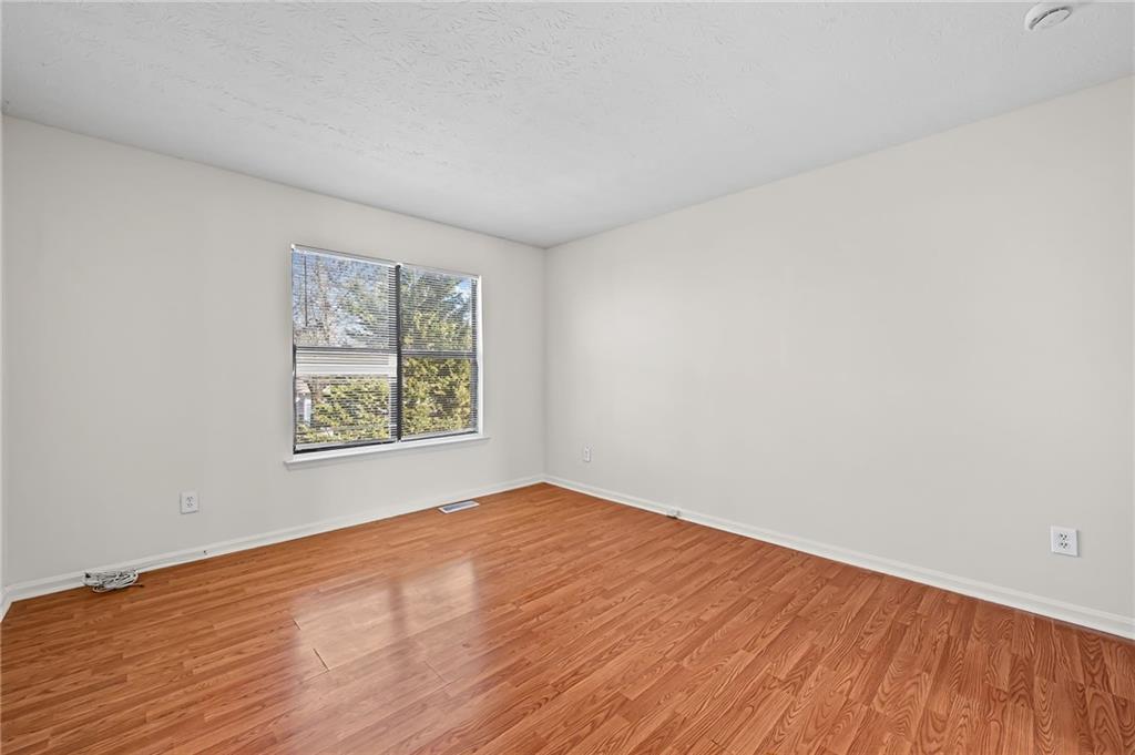 1222 Ridgecrest Lane Southeast Smyrna, GA 30080 - Photo 25 of 27 a view of an empty room with wooden floor and a window