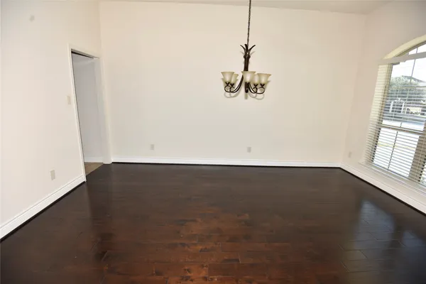an empty room with wooden floor and entrance