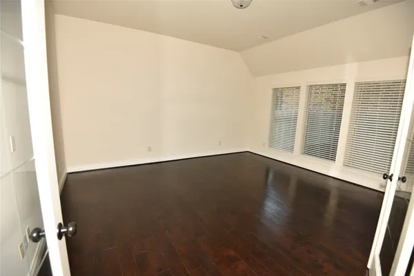 a view of a living room with wooden floor and a window