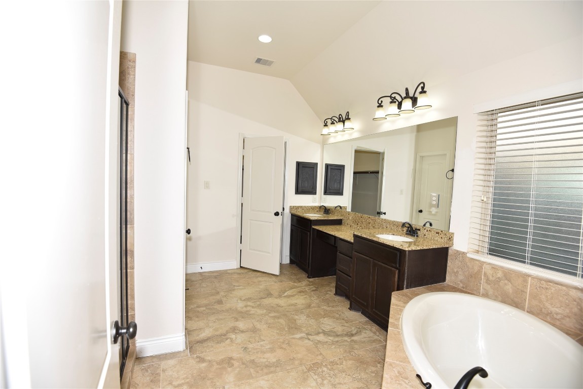 18610 Lena Trail Drive Spring, TX 77388 - Photo 41 of 47 a large bathroom with a tub double vanity sink and mirror