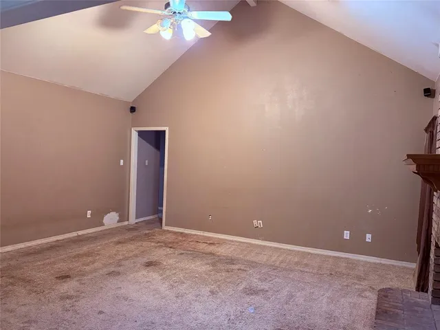 a view of an empty room with a chandelier fan
