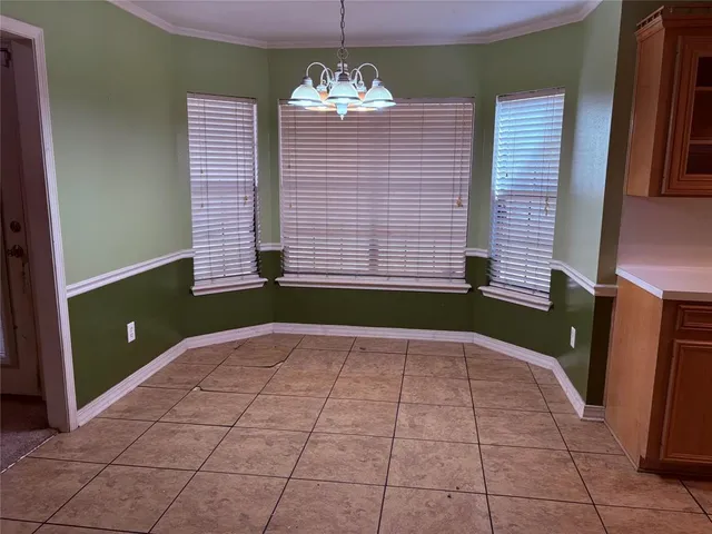 a view of an empty room with a window and a chandelier