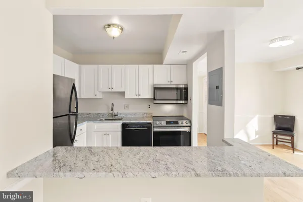 a kitchen with stainless steel appliances granite countertop a refrigerator stove microwave and sink