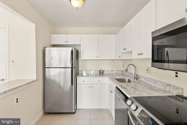 a kitchen with a sink a refrigerator and a stove top oven