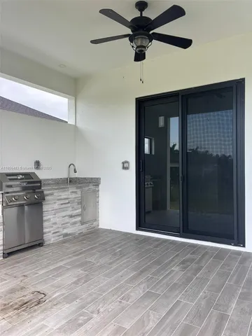 a kitchen with stainless steel appliances wooden floor and chandelier
