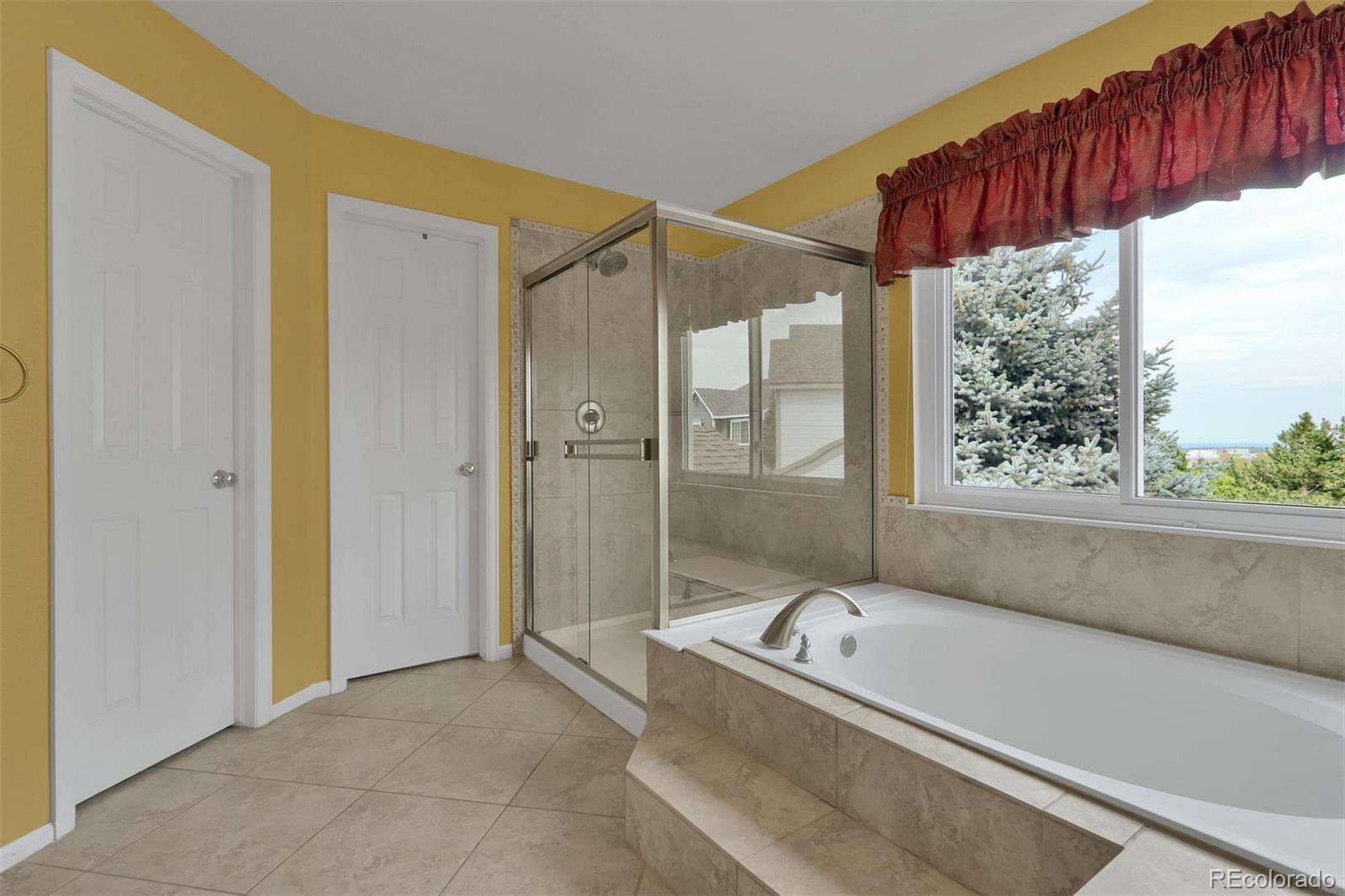 10115 Spring Water Court Highlands Ranch, CO 80129 - Photo 18 of 35 a bathroom with a tub a mirror and a shower