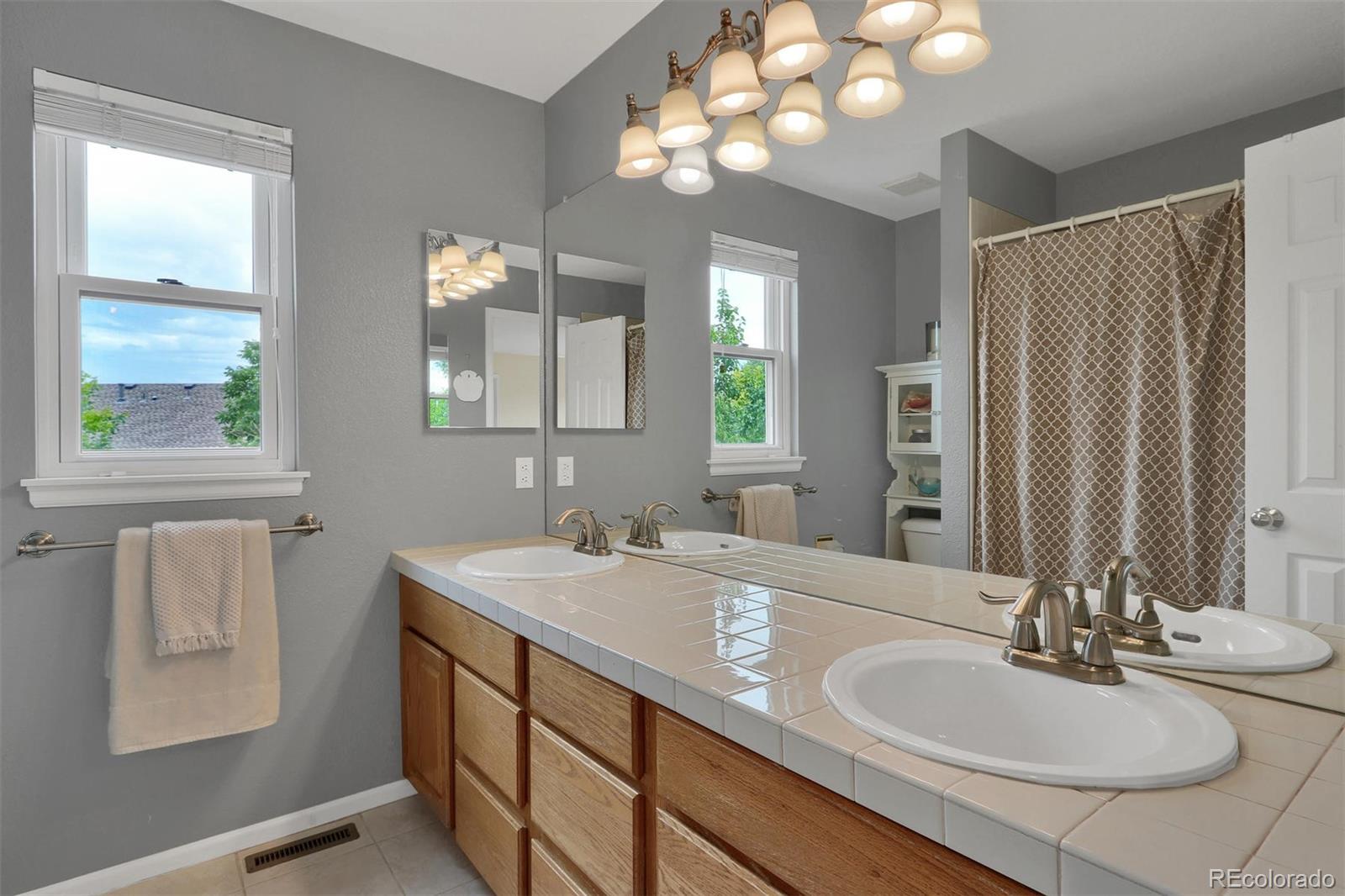 10115 Spring Water Court Highlands Ranch, CO 80129 - Photo 23 of 35 a bathroom with a double vanity sink and a mirror