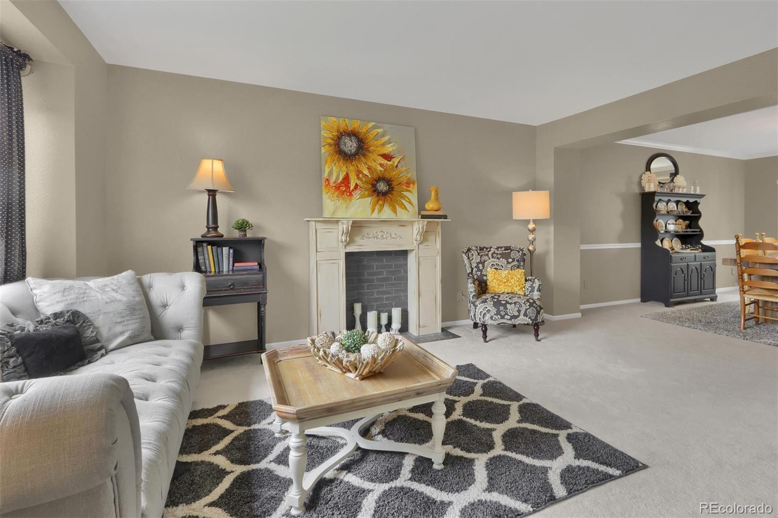 10115 Spring Water Court Highlands Ranch, CO 80129 - Photo 3 of 35 a living room with furniture a fireplace and decor