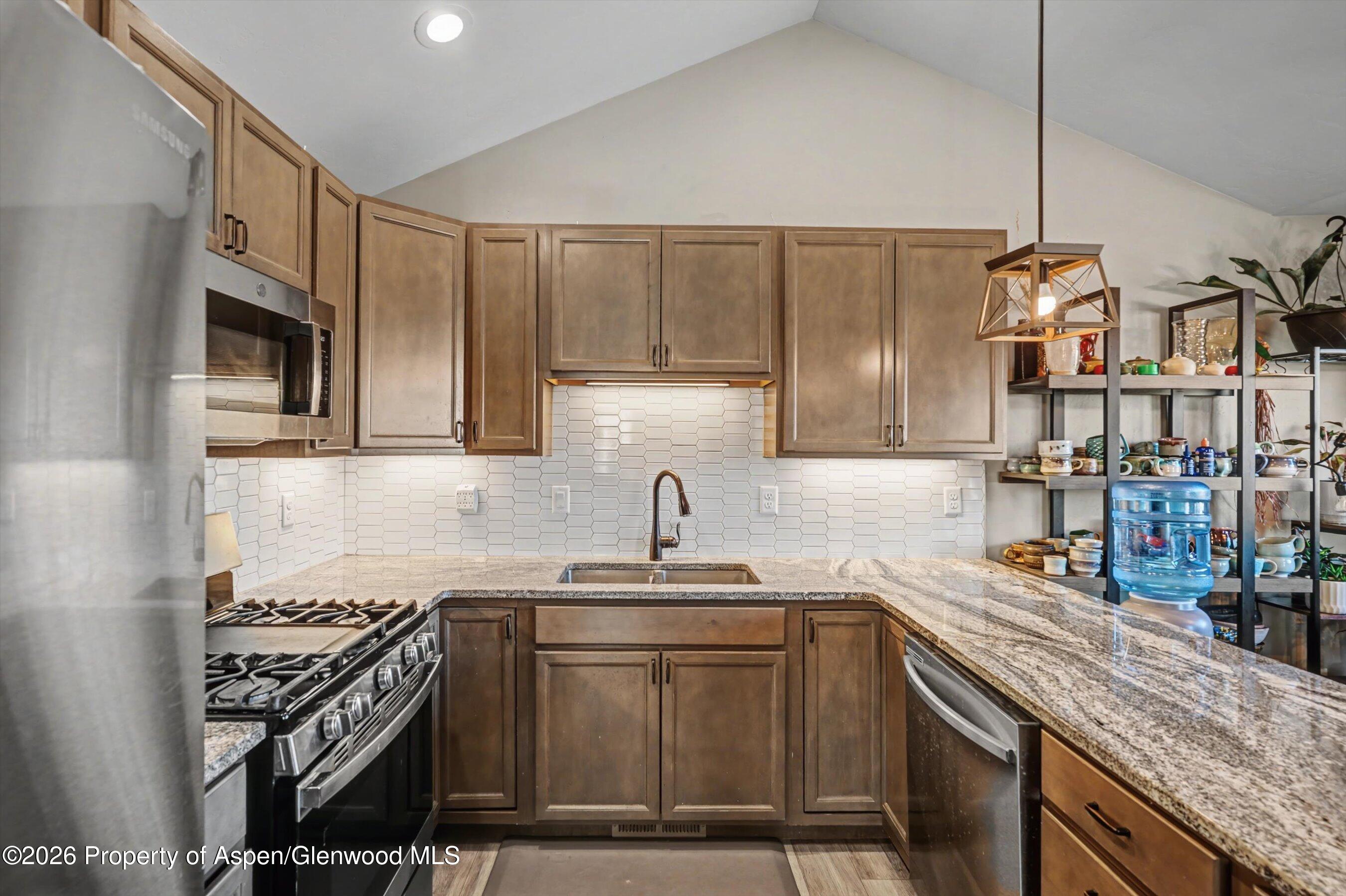 157 Willow Circle Rifle, CO 81650 - Photo 5 of 18 a kitchen with stainless steel appliances granite countertop a sink stove and cabinets