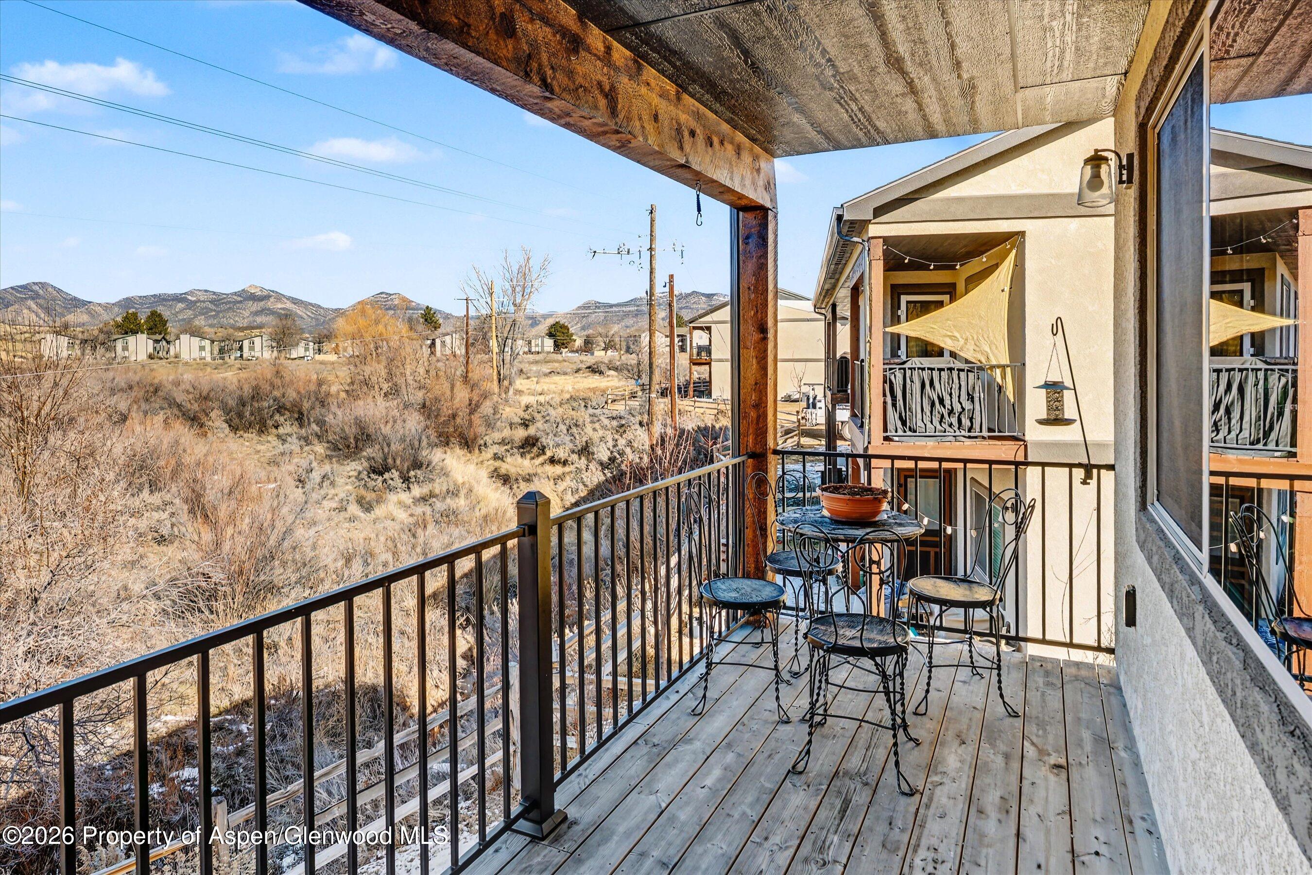 157 Willow Circle Rifle, CO 81650 - Photo 7 of 18 a view of a balcony with furniture and wooden floor