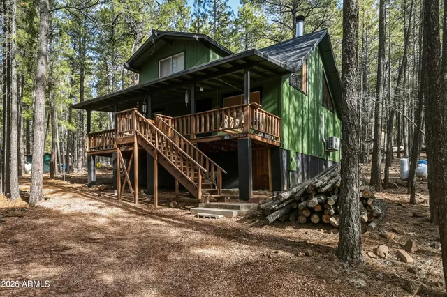 a view of a house with a small yard and wooden fence