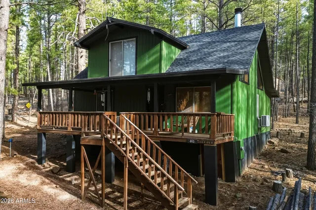 a view of a house with large windows and wooden fence