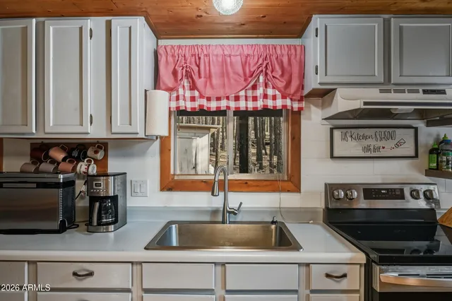 a kitchen with stainless steel appliances granite countertop a sink and a stove