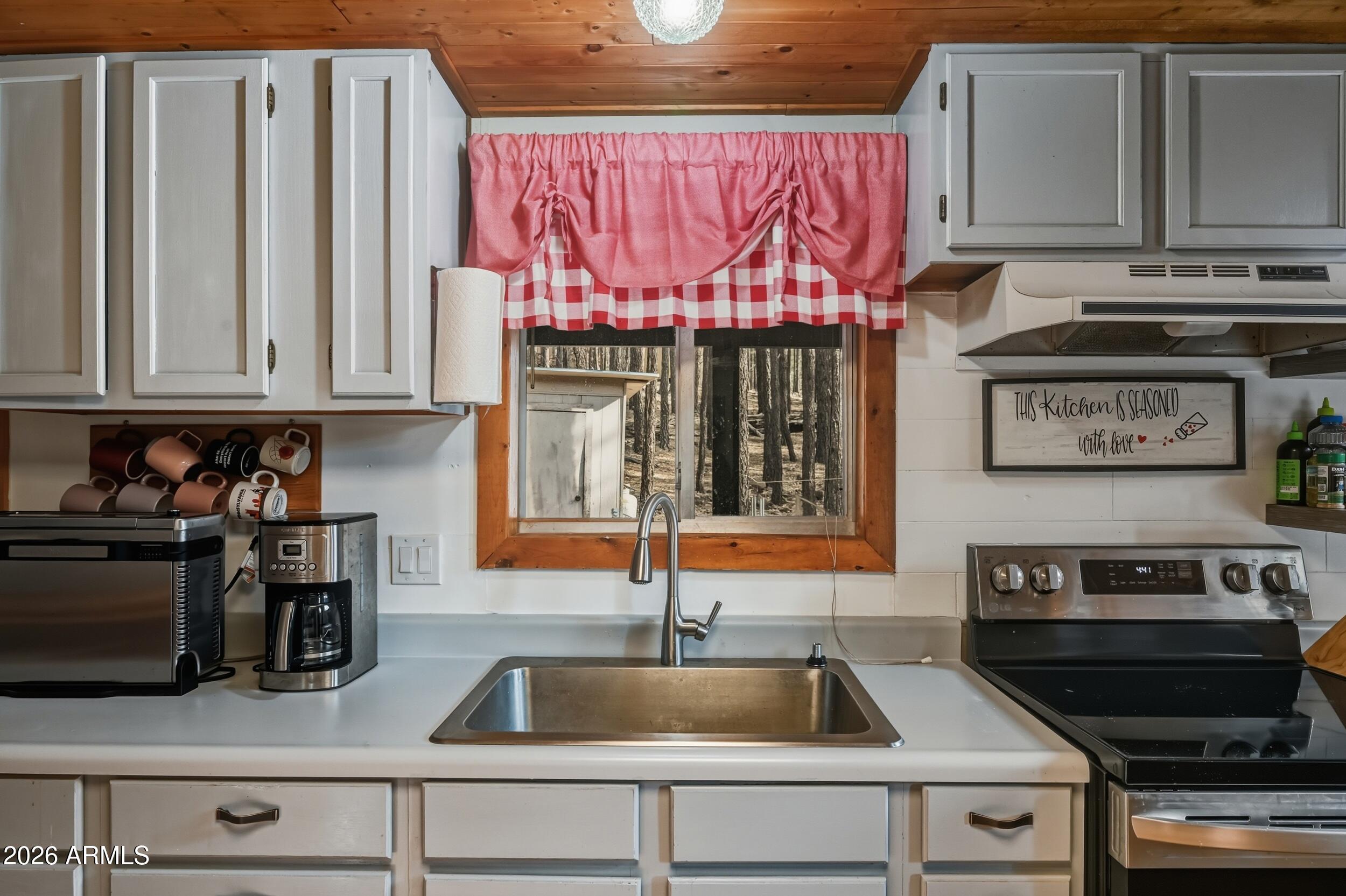 463 Long Valley Road Happy Jack, AZ 86024 - Photo 9 of 25 a kitchen with stainless steel appliances granite countertop a sink and a stove