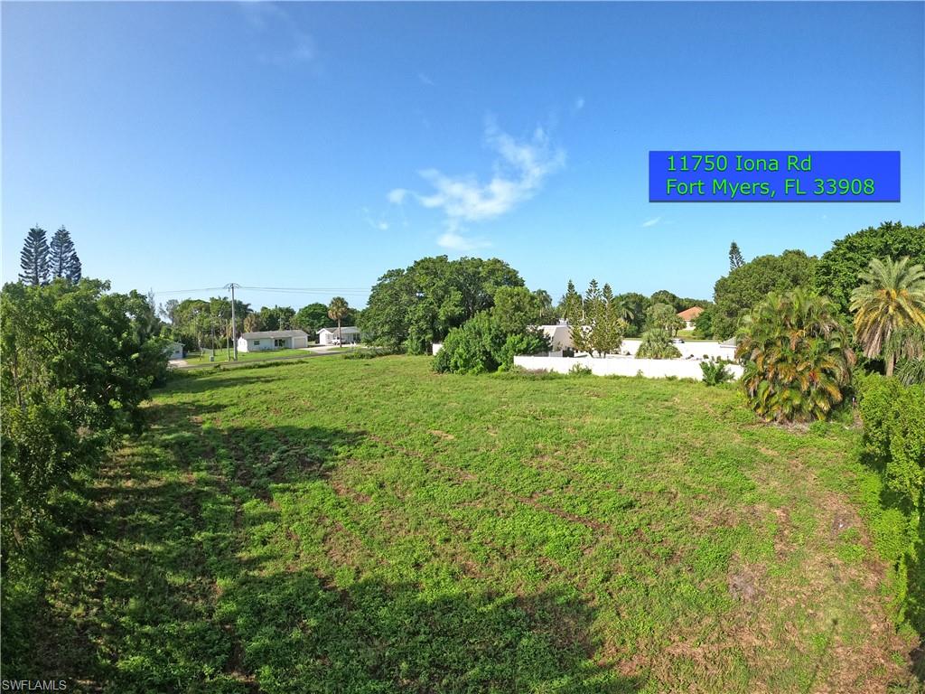 11750 Iona Road Fort Myers, FL 33908 - Photo 9 of 13 a view of a yard with an tree and a bench